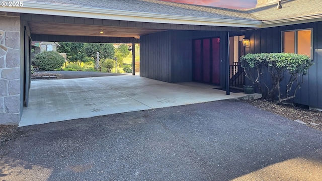 garage with a carport and aphalt driveway