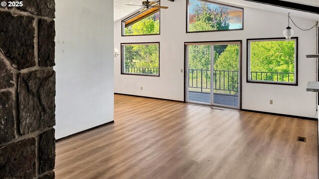 spare room featuring high vaulted ceiling, wood finished floors, baseboards, and ceiling fan