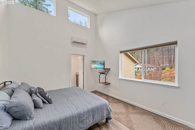 bedroom with a wall mounted air conditioner and a high ceiling