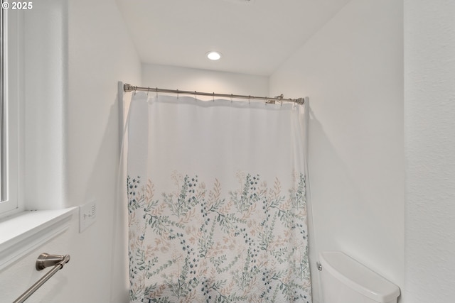 bathroom featuring curtained shower and toilet