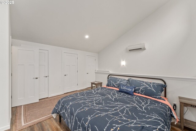 119/121 Tioga Ln, Idleyld Park, OR 97447 - bedroom with a wall mounted air conditioner, wood finished floors, lofted ceiling, and recessed lighting