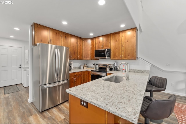 119/121 Tioga Ln, Idleyld Park, OR 97447 - kitchen featuring appliances with stainless steel finishes, a sink, a peninsula, brown cabinetry, and recessed lighting