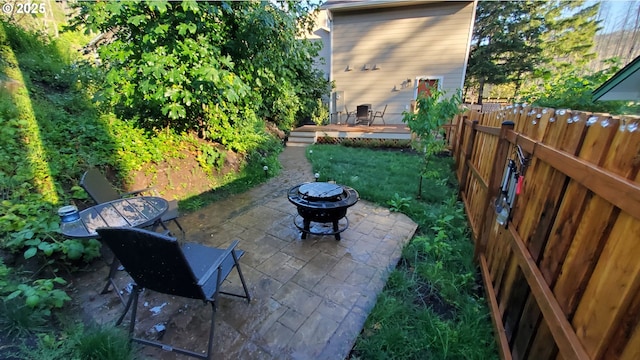 view of patio featuring a wooden deck and a fire pit