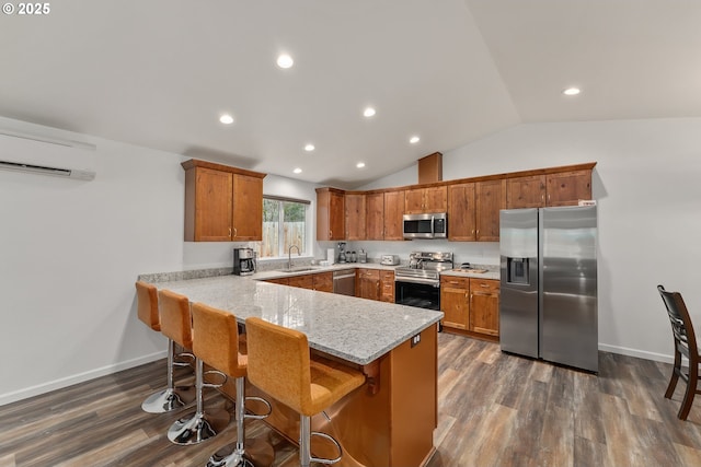 119/121 Tioga Ln, Idleyld Park, OR 97447 - kitchen featuring appliances with stainless steel finishes, a peninsula, brown cabinetry, a wall unit AC, and lofted ceiling