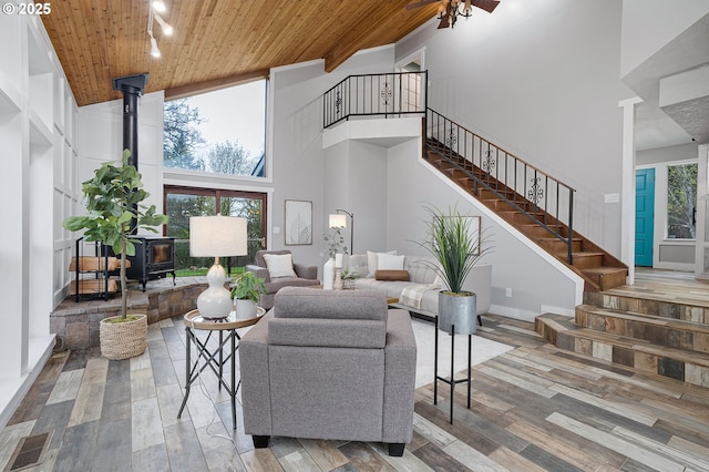 19434 S Logan Dr, Beavercreek, OR 97004 - living room with a high ceiling, a wood stove, stairway, wooden ceiling, and wood finished floors