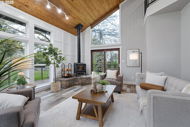 19434 S Logan Dr, Beavercreek, OR 97004 - living area featuring a high ceiling, track lighting, a wood stove, wood ceiling, and wood finished floors