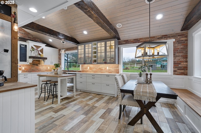 19434 S Logan Dr, Beavercreek, OR 97004 - kitchen featuring wood counters, light wood-style flooring, ventilation hood, white cabinetry, and brick wall