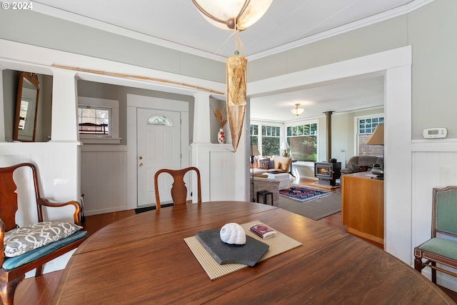 dining space with wainscoting, wood finished floors, a decorative wall, and ornamental molding