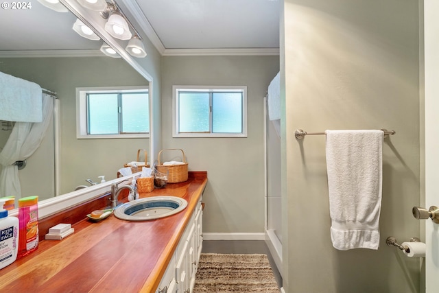 bathroom featuring a shower with curtain, vanity, crown molding, and baseboards
