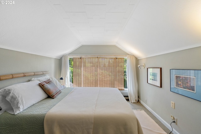 carpeted bedroom with baseboards and lofted ceiling