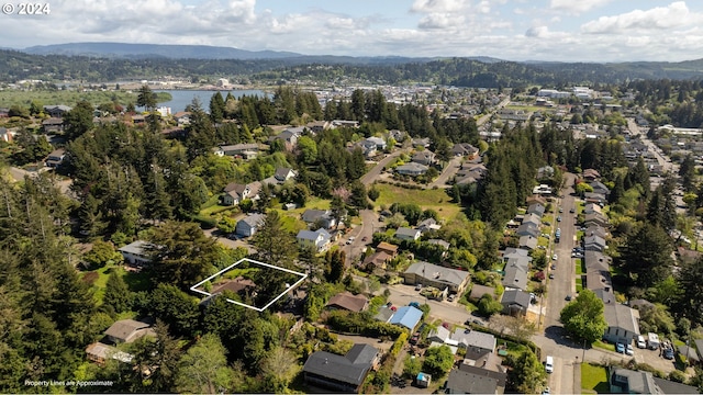 birds eye view of property with a residential view, a water and mountain view, and a wooded view