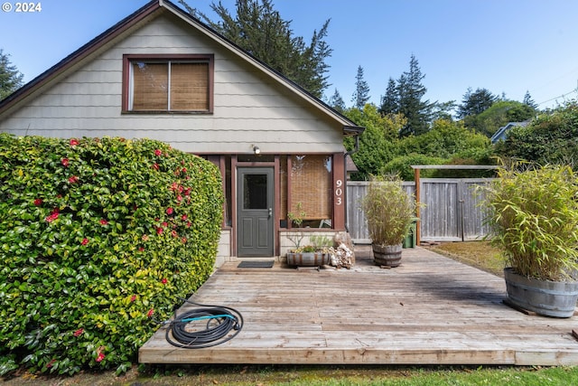 rear view of property featuring a deck and fence