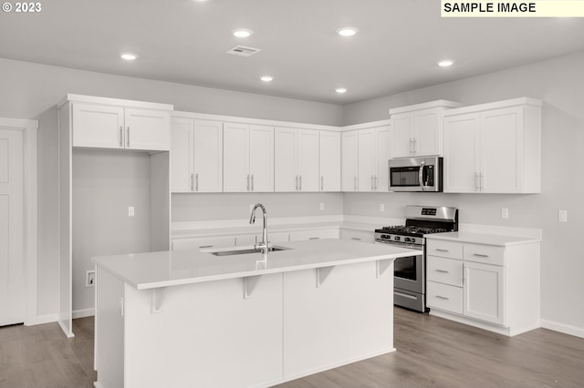 6286 SE 20th St, Gresham, OR 97080 - kitchen with stainless steel appliances, a sink, white cabinets, an island with sink, and light wood finished floors