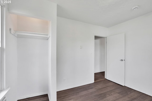 unfurnished bedroom with baseboards and wood finished floors