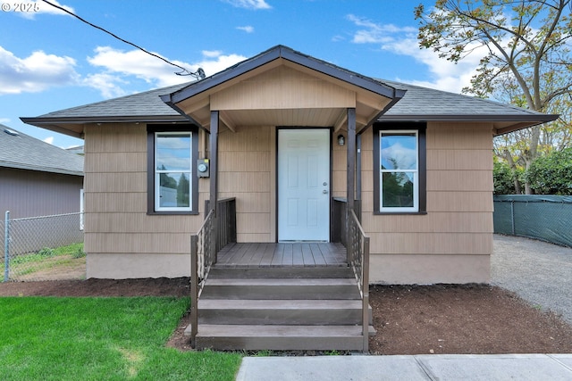 view of front of property with fence and roof with shingles