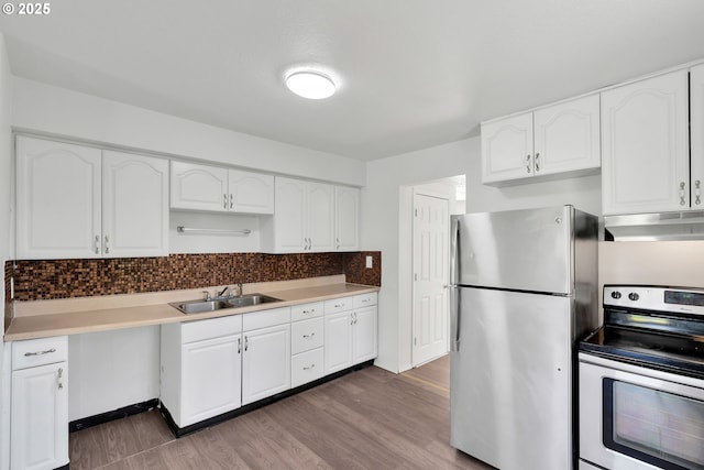 kitchen featuring a sink, appliances with stainless steel finishes, under cabinet range hood, and wood finished floors
