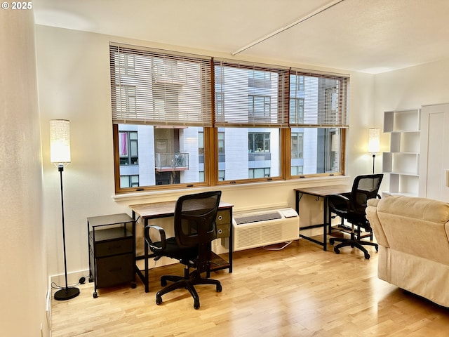 office space featuring wood finished floors and a wall unit AC