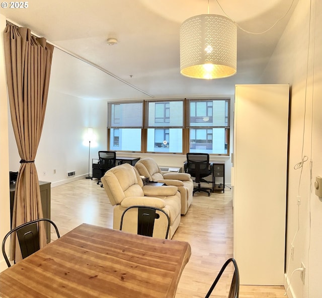 dining room with baseboards, visible vents, and light wood-style flooring