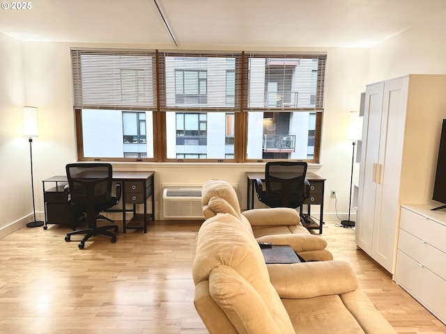 living area with baseboards, a wall mounted AC, and wood finished floors
