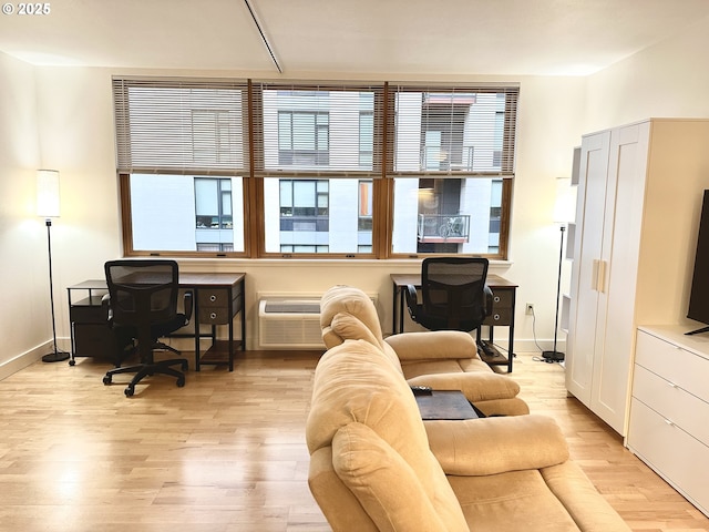 interior space with light wood-type flooring and an AC wall unit