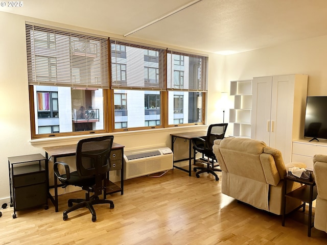 office area featuring a wall mounted air conditioner and light wood-type flooring