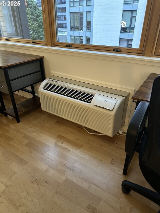 office area with a wall mounted AC and light hardwood / wood-style floors