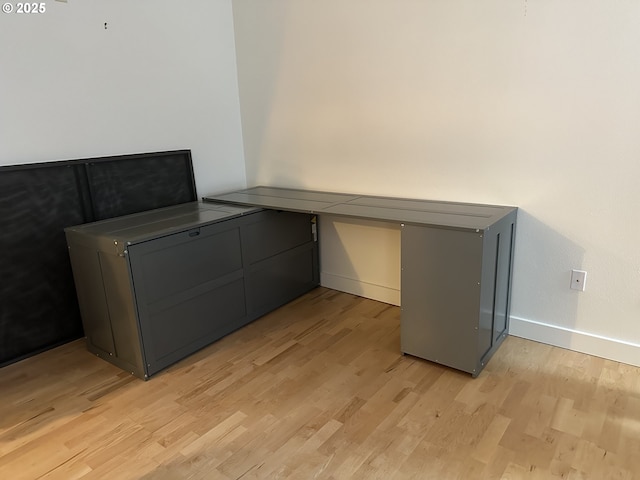unfurnished office featuring light wood finished floors and baseboards