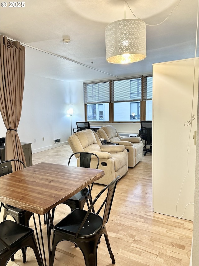 dining room with light wood-style flooring and baseboards