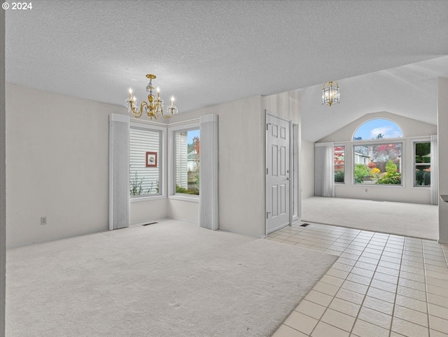 tiled spare room with lofted ceiling, a textured ceiling, and an inviting chandelier