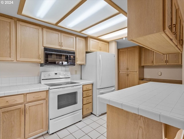 kitchen featuring light tile patterned floors, white appliances, tile counters, and light brown cabinetry