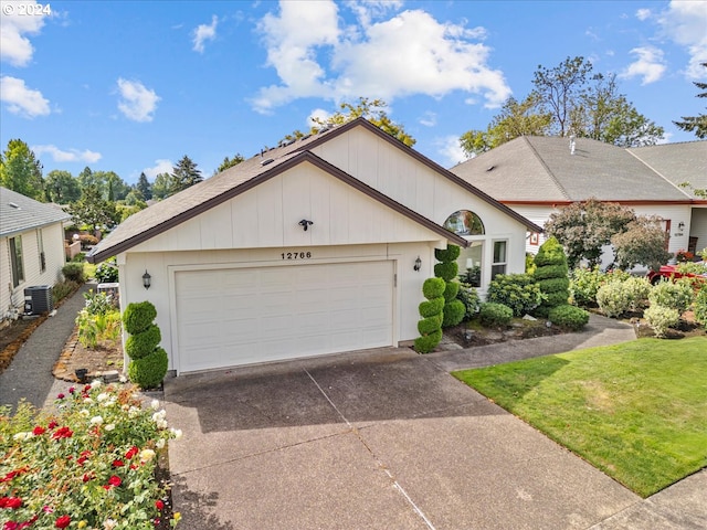 view of front of house with a garage, a front lawn, and central air condition unit