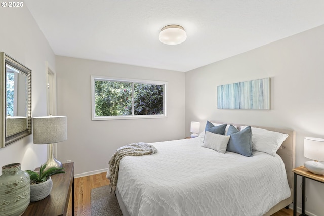 bedroom featuring baseboards and wood finished floors