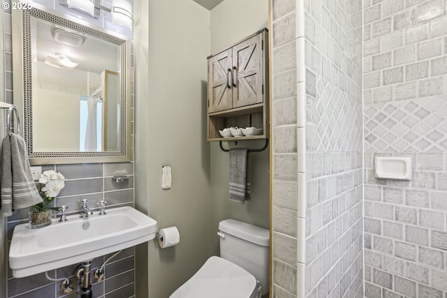 bathroom featuring toilet, a sink, and curtained shower