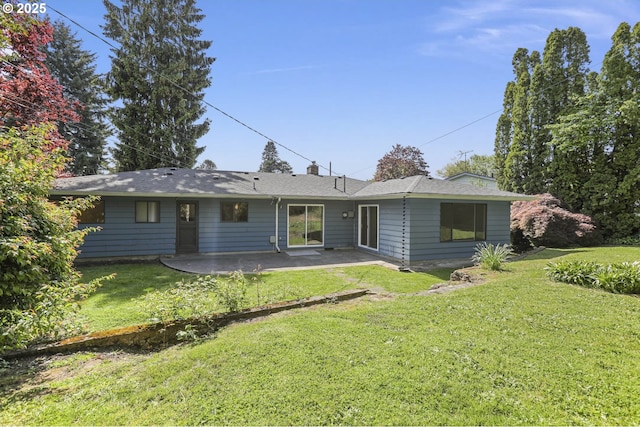 back of house with a patio, a yard, and a chimney