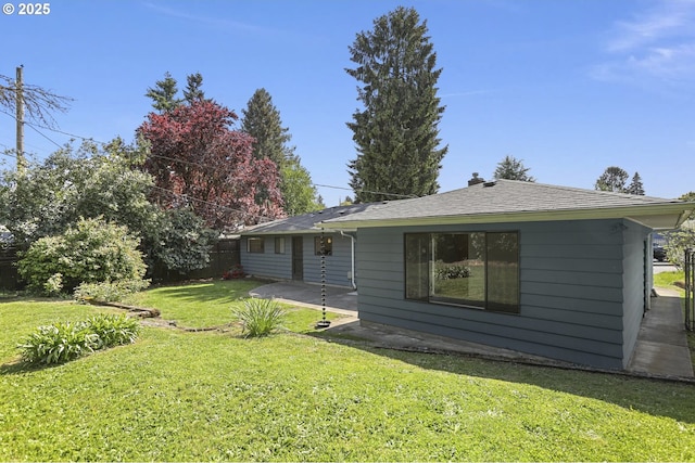 rear view of property featuring a lawn, fence, and a patio
