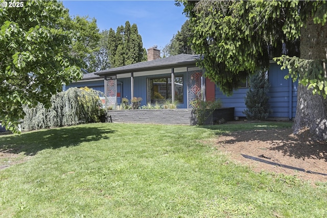 rear view of house with a lawn and a chimney