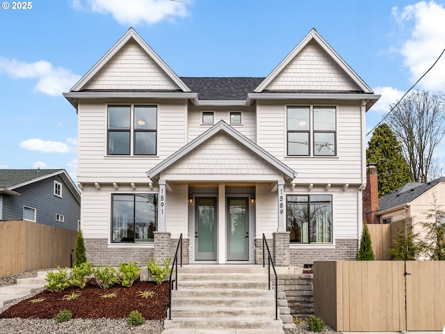 view of front of house featuring a gate, fence, and brick siding