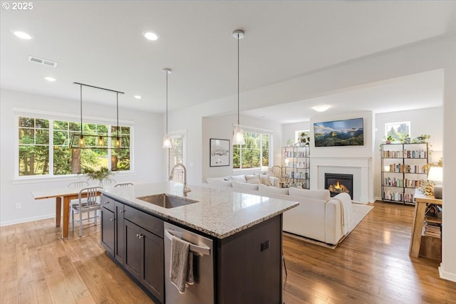 7010 SW Barr Ln, Tualatin, OR 97062 - kitchen featuring stainless steel dishwasher, a glass covered fireplace, light wood finished floors, dark brown cabinets, and recessed lighting