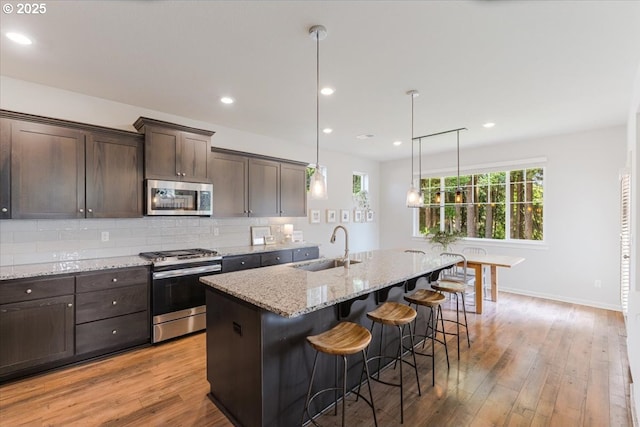 7010 SW Barr Ln, Tualatin, OR 97062 - kitchen with stainless steel appliances, dark brown cabinets, plenty of natural light, a breakfast bar area, and recessed lighting