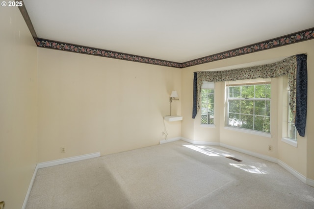 unfurnished room featuring carpet floors, baseboards, and visible vents