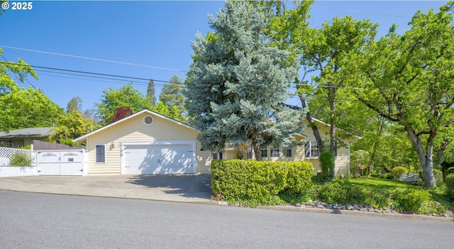 view of front of house with fence, driveway, and a garage