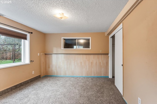 spare room featuring carpet flooring and a textured ceiling