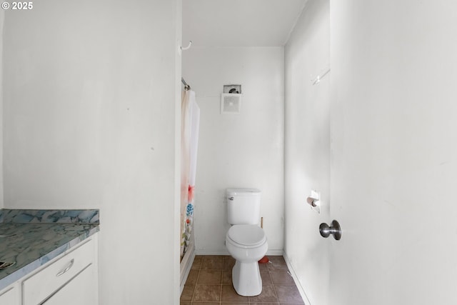 bathroom with toilet, tile patterned floors, vanity, curtained shower, and baseboards