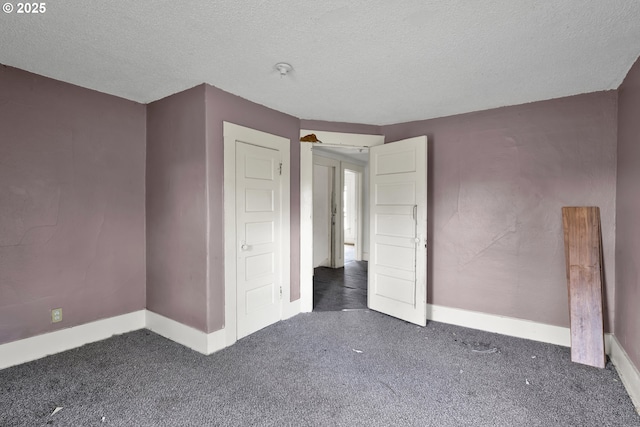 unfurnished bedroom featuring carpet flooring, baseboards, and a textured ceiling