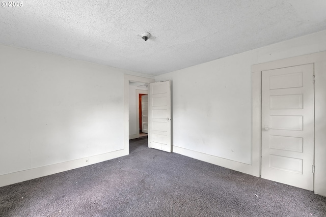 spare room featuring carpet floors and a textured ceiling