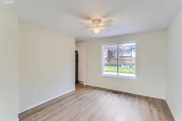 unfurnished room featuring baseboards, light wood-style flooring, ceiling fan, and visible vents