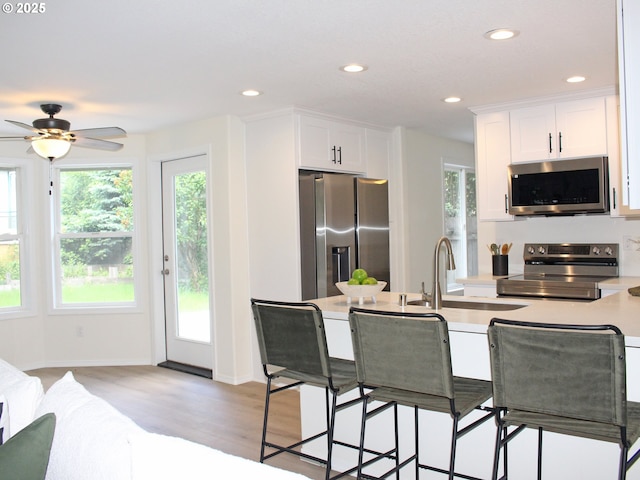16400 NE 12th St, Vancouver, WA 98684 - kitchen with stainless steel appliances, a sink, white cabinets, recessed lighting, and light wood-type flooring
