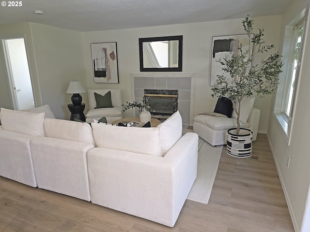 16400 NE 12th St, Vancouver, WA 98684 - living area featuring light wood-type flooring, a tiled fireplace, and baseboards
