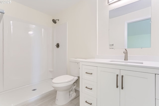 bathroom featuring toilet, a shower stall, and vanity