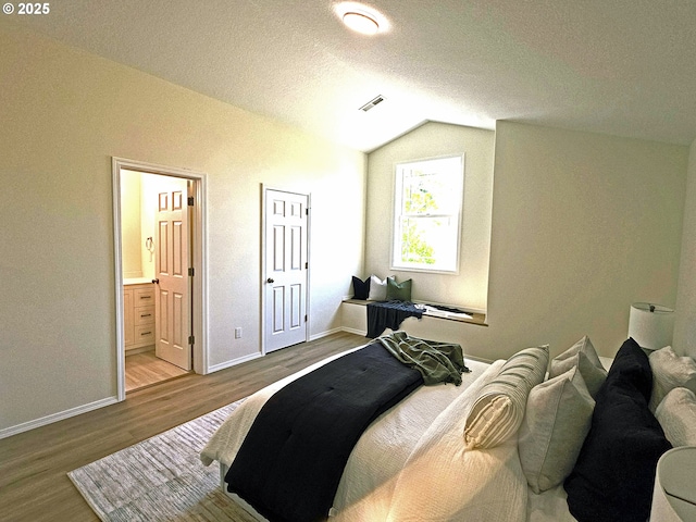 16400 NE 12th St, Vancouver, WA 98684 - bedroom with wood finished floors, vaulted ceiling, baseboards, a textured ceiling, and ensuite bathroom